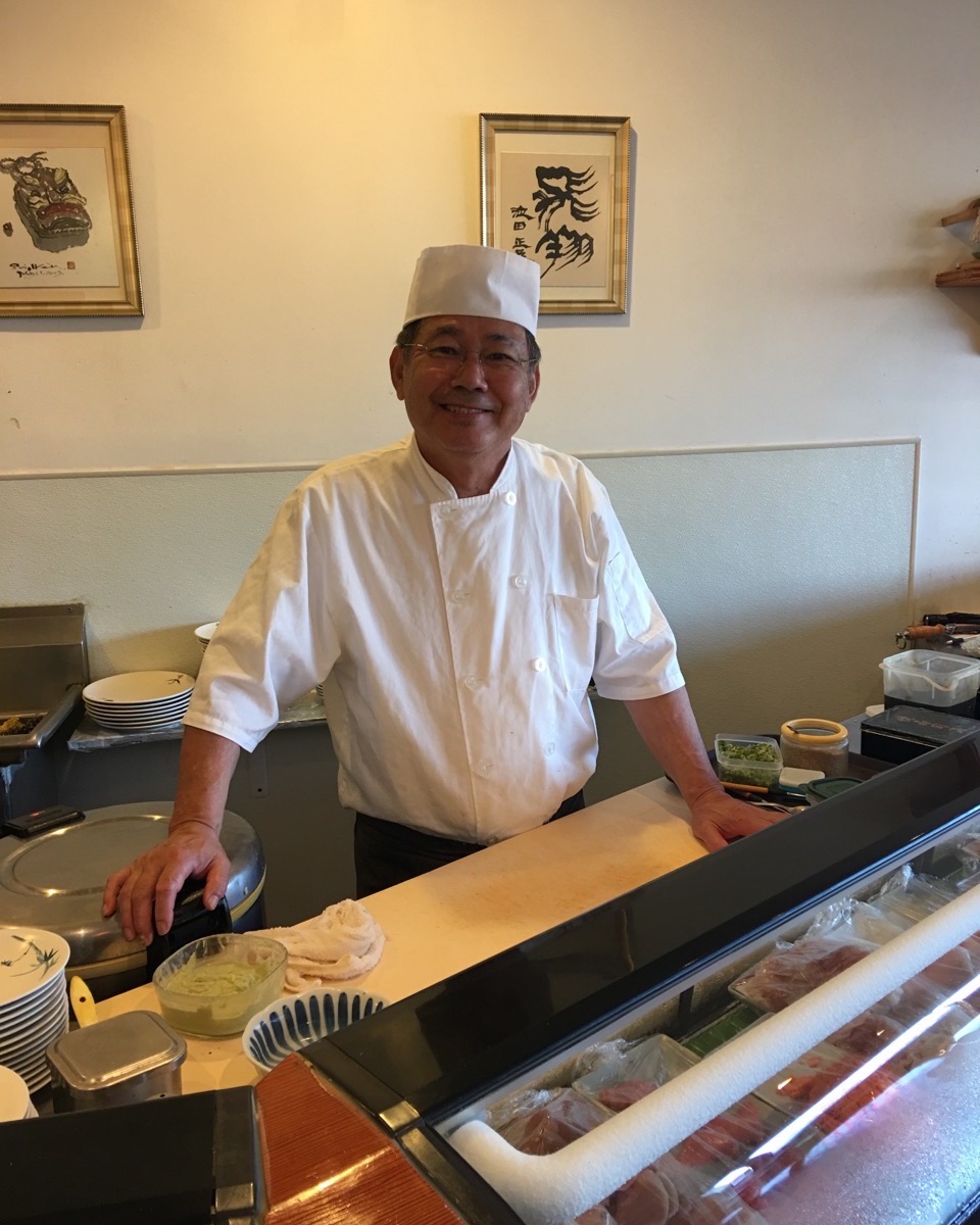 Master Sushi Chef Murata Shinji, smiling behind his counter.